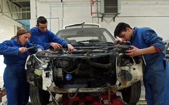 trois eleves reparant une voiture